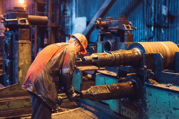 Trabalhador da indústria pesada trabalhando duro na máquina. ambiente industrial áspero.