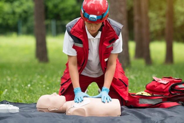 Trabalhador da saúde a praticar com um boneco de reanimação cardíaca no parque