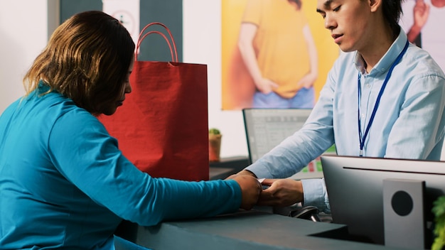 Foto trabalhador dando saco a um cliente viciado em compras