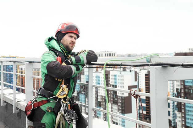 Trabalhador de alpinismo industrial de retrato de uniforme no telhado