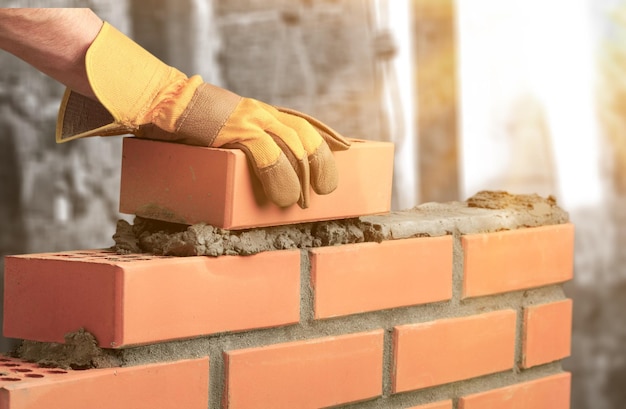 Foto trabalhador de casa de camada de construção de alvenaria de cimento pedreiro