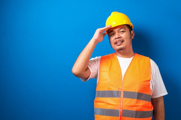 Trabalhador de construção asiática gordo usando capacete de segurança estressado com a mão na cabeça