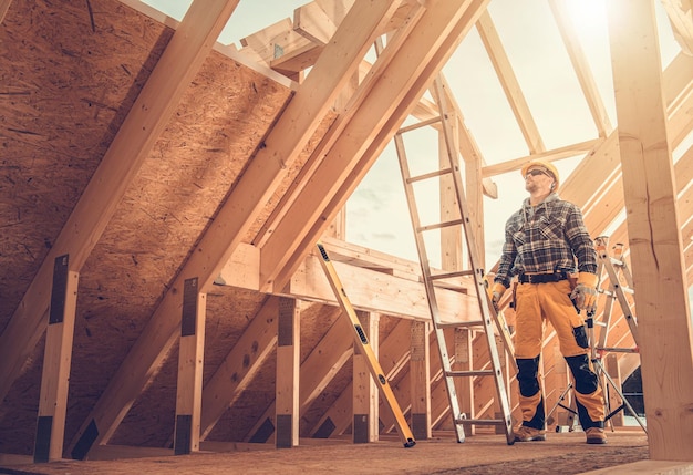 Trabalhador de construção profissional dentro de uma casa de madeira recém-construída