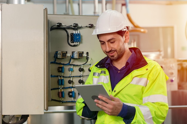 Trabalhador de engenheiro trabalhando verificando a caixa de fusíveis de eletricidade de manutenção e a linha de energia na fábrica.