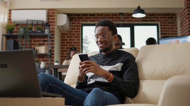 Trabalhador de escritório enviando mensagens de texto nas mídias sociais usando telefone celular, usando tecnologia para navegar na internet e trabalhar em análise. Empregado do sexo masculino segurando smartphone. Tiro de tripé.