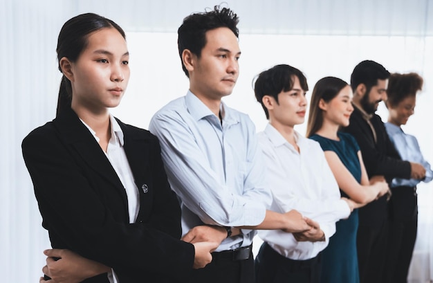 Trabalhador de escritório multirracial feliz e sorridente dá as mãos em uma linha promovendo sinergia e colaboração para o sucesso do negócio Diversos vínculos profissionais de trabalhadores de escritório no local de trabalho moderno Concord