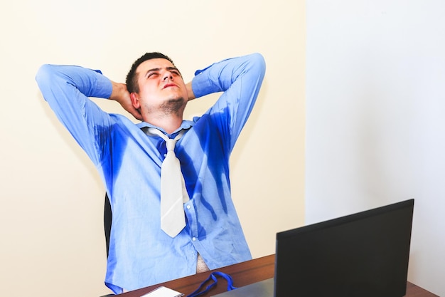 Trabalhador de escritório suando. Camisa molhada. Condições de trabalho ruins. Gerente infeliz. Calor de verão. Sem ar condicionado no edifício.