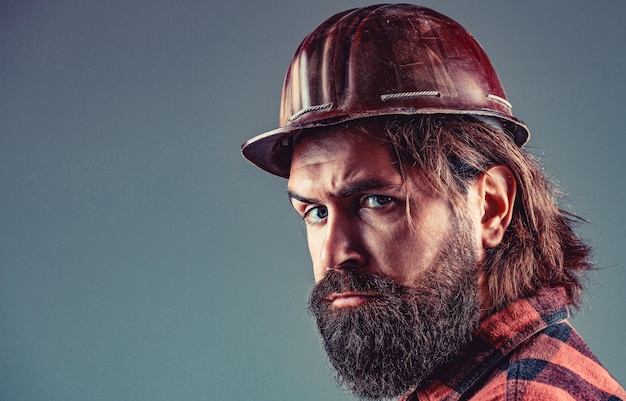 Trabalhador de homem barbudo com barba na construção de capacete ou capacete indústria de construtores de homem