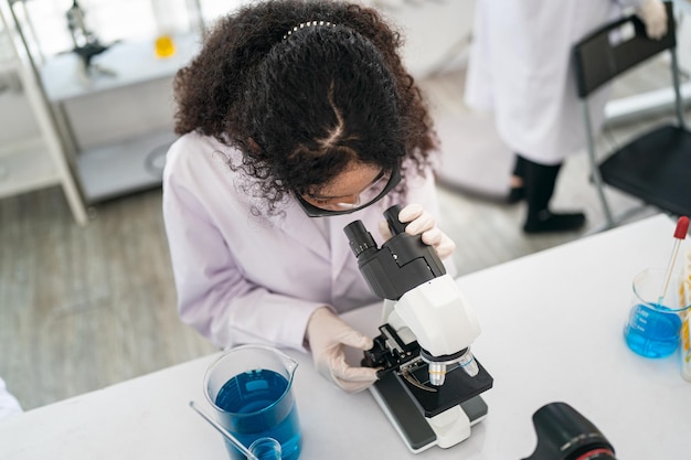 Foto trabalhador de laboratório usando lupa no microscópio