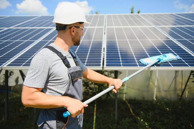 Trabalhador de limpeza de painéis solares após a instalação ao ar livre