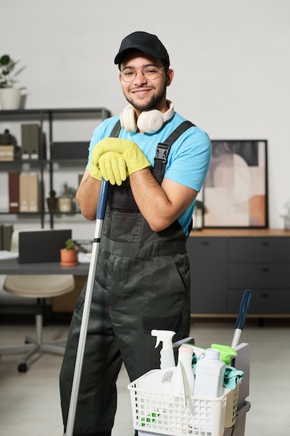Trabalhador de limpeza em uniforme lavando o chão