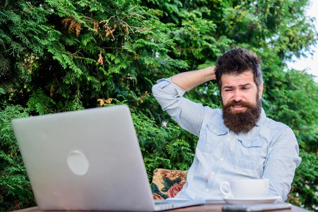 Foto trabalhador de mídia de massa on-line escreva artigo para revista on-line laptop hipster barbudo navegando na internet homem procurando inspiração repórter jornalista rotina diária trabalhando on-line encontre tópico escreva