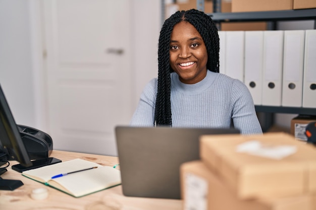 Trabalhador de negócios de comércio eletrônico de mulher afro-americana usando laptop no escritório