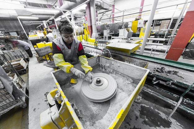 Trabalhador de produção de vidro trabalhando com equipamentos da indústria em fundo de fábrica