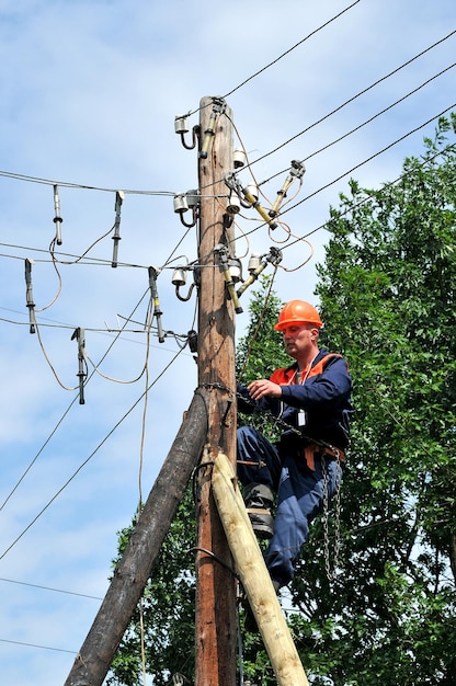 Trabalhador de reparador eletricista eletricista instala o aterramento na linha de energia antes de repará-lo.
