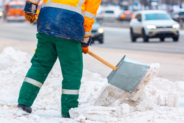 Trabalhador de serviços comunais varre neve da estrada no inverno, limpando estradas e ruas da cidade durante a tempestade de neve. moscou, rússia.