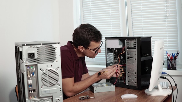 Trabalhador de serviços informáticos que repara computadores avariados no escritório e atualiza computadores