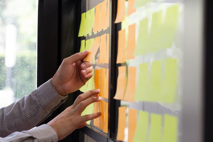 Foto trabalhador de ti, rastreando suas tarefas no quadro kanban.