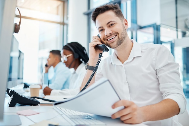 Trabalhador de vendas de telemarketing ou atendimento ao cliente sorrindo e falando em um telefone vendendo seguro Jovem agente de call center feliz animado por boas notícias no telefone e trabalhando em um escritório
