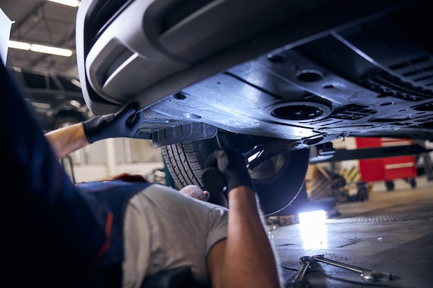 Trabalhador do sexo masculino consertando carro em posto de gasolina