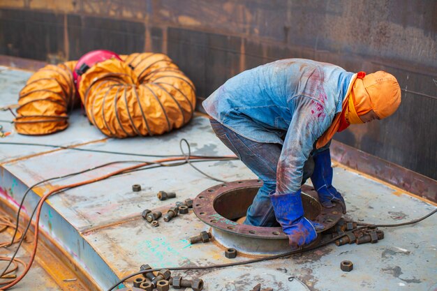 Trabalhador do sexo masculino dentro do tanque de inspeção visual de armazenamento do tanque do pontão no espaço confinado é o soprador de ar