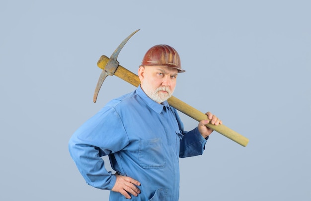 Trabalhador do sexo masculino mineiro de macacão com picareta, construção e obras de construção homem barbudo de uniforme