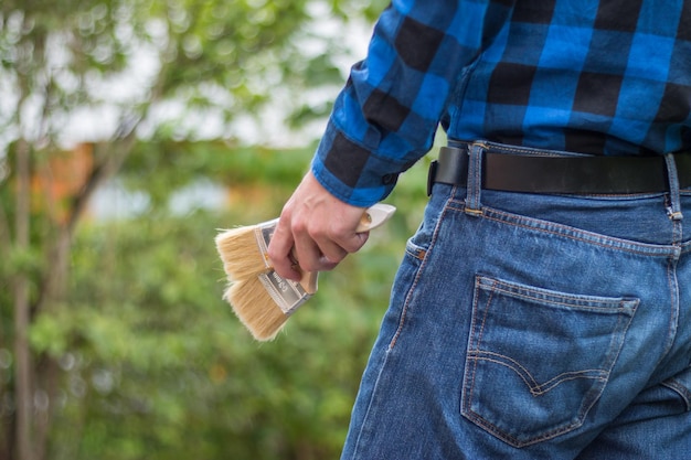 Trabalhador doméstico Vista traseira de um jovem com pincéis no bolso