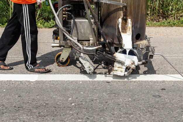 Foto trabalhador e trabalho de máquina de pintura na rua na tailândia