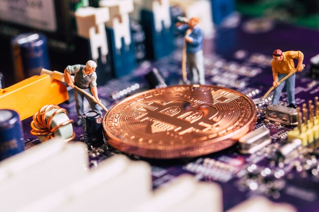 Trabalhador em miniatura cavar mineiro de bitcoin ouro na placa de circuito eletrônico