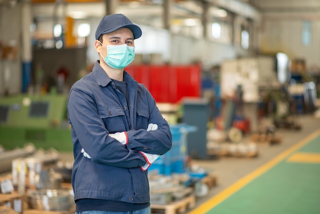 Foto trabalhador em uma fábrica usando uma máscara durante a pandemia de coronavírus covid-19
