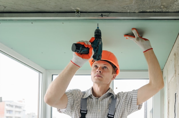 Trabalhador está consertando o drywall.