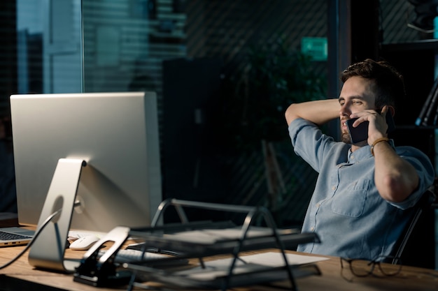 Trabalhador exausto com telefone no escritório