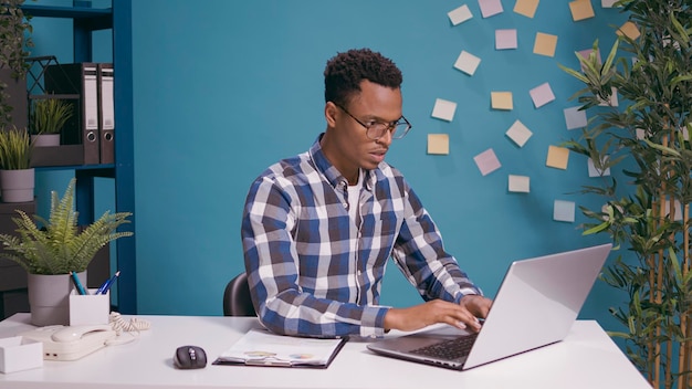 Trabalhador furioso se sentindo tenso com o erro de trabalho no laptop, tendo uma reação agressiva na mesa. Pessoa perturbada gritando e se sentindo irritada enquanto trabalha na estratégia freelancer no computador.