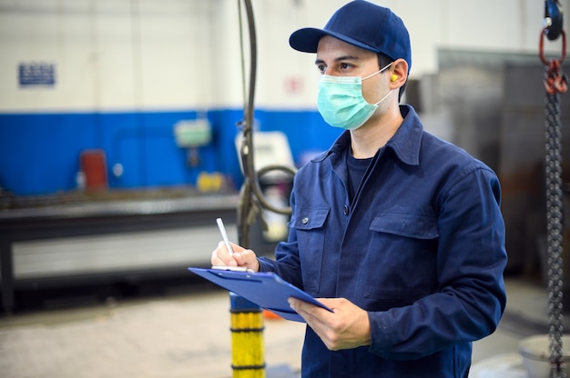 Trabalhador industrial escrevendo em um documento em uma fábrica