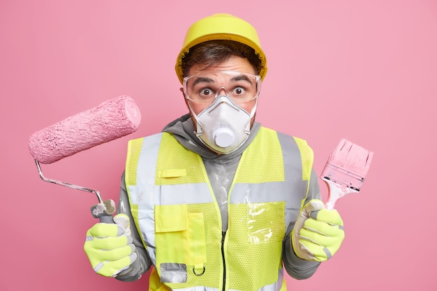 trabalhador industrial usa respirador de proteção e óculos de segurança segurando ferramentas de conserto indo redecorar algo