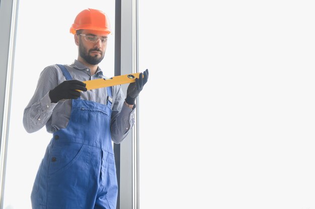 Foto trabalhador instalando janela de plástico dentro de casa