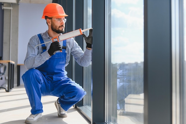 Foto trabalhador instalando janela de plástico dentro de casa