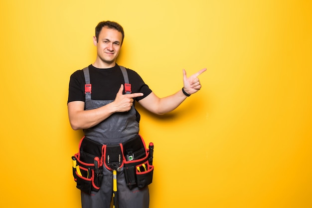 Foto trabalhador jovem sorridente, apontando para o espaço da cópia