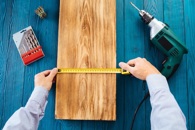 Trabalhador manual em uniforme azul funciona com chave de fenda elétrica automática. concepção de renovação de casa.