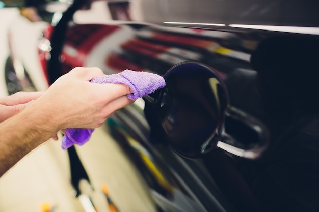 Trabalhador mãos instala filme de proteção de pintura de carro