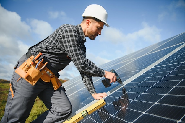 Trabalhador masculino de uniforme ao ar livre com baterias solares em dia ensolarado