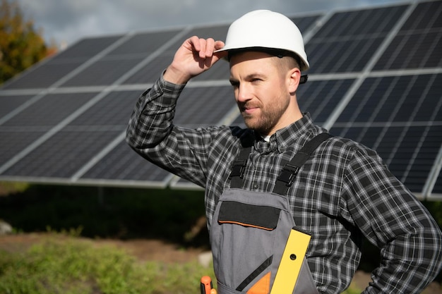 Trabalhador masculino de uniforme ao ar livre com baterias solares em dia ensolarado