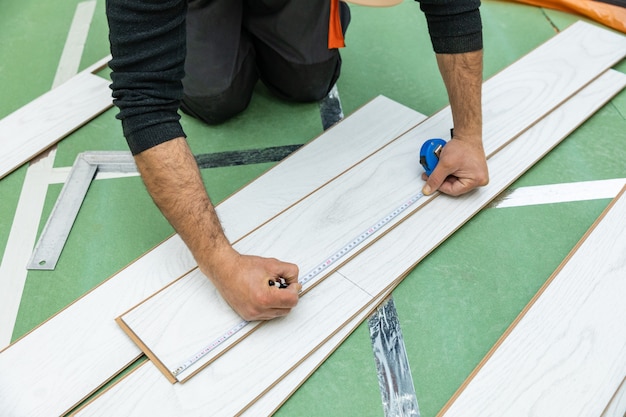 Foto trabalhador mede o comprimento do laminado de madeira branca