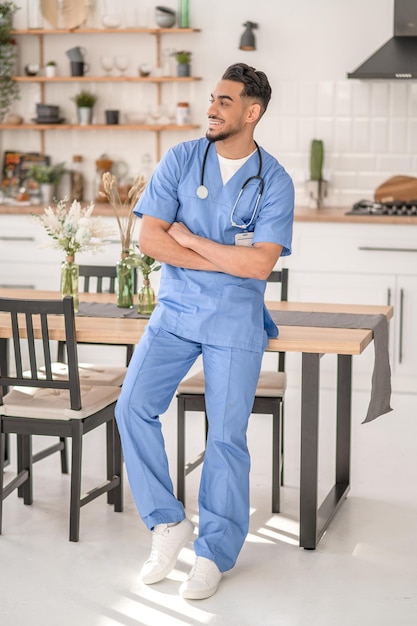 Trabalhador médico sorridente em pé na cozinha