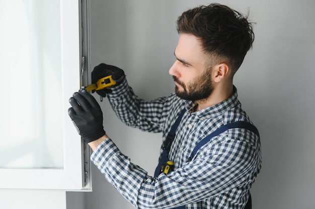 Trabalhador na instalação de janela upvc de plástico branco em casa