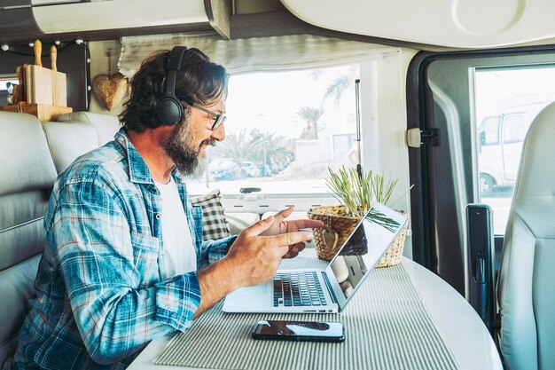 Foto trabalhador on-line moderno, trabalho inteligente, estilo de vida nômade digital em caravana, viagens, pessoas e tecnologia, trabalho de negócios alternativos, criador de conteúdo, influenciador, homem usando computador, laptop e conexão.