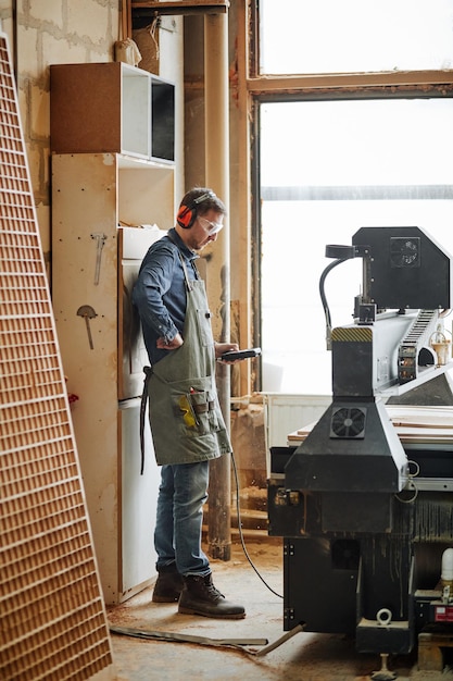 Foto trabalhador operando máquina na carpintaria