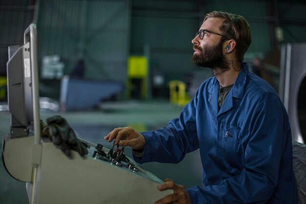 Trabalhador operando máquinas no painel de controle na fábrica