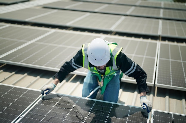 Trabalhador profissional instalando painéis solares no telhado de uma casa