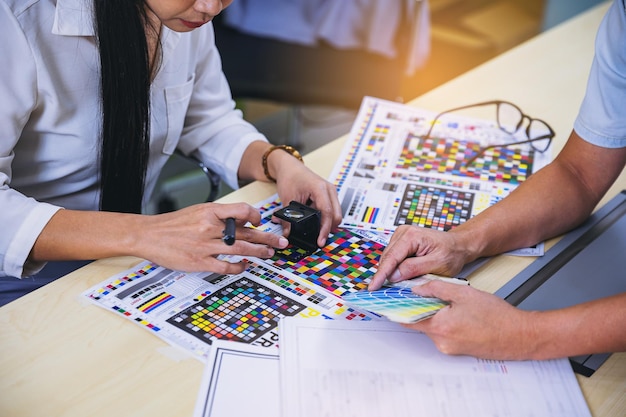 Foto trabalhador que verifica a qualidade de impressão de impressão gráfica de provas na indústria de impressão